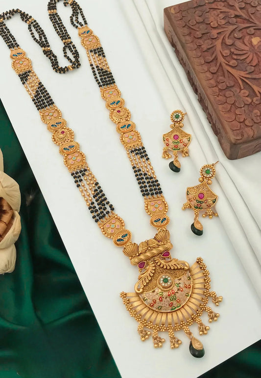 Traditional gold mangalsutra necklace with black beads and matching gold earrings decorated with green and pink stones